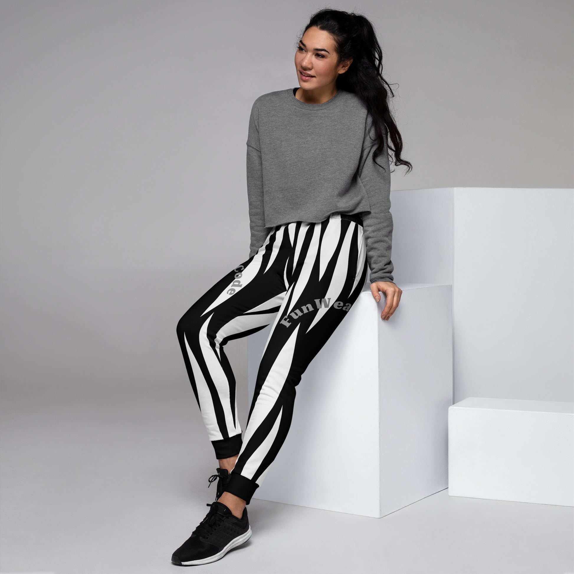 Woman wearing a gray sweatshirt and black and white striped sweatpants with a 'Fun Wear Code' logo on a gray background
